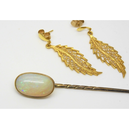 587 - A yellow metal lapel pin set with a large white opal, dimensions approx 15.5mm x 9.5mm x 4.6mm, weig... 