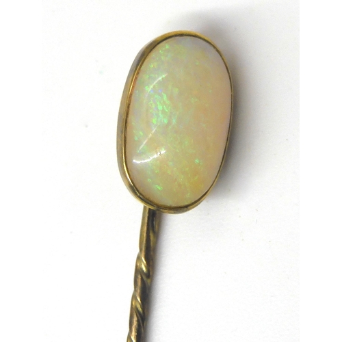 587 - A yellow metal lapel pin set with a large white opal, dimensions approx 15.5mm x 9.5mm x 4.6mm, weig... 