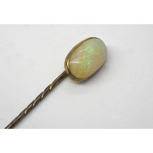 587 - A yellow metal lapel pin set with a large white opal, dimensions approx 15.5mm x 9.5mm x 4.6mm, weig... 