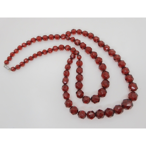 602 - A string of cherry amber coloured beads, weight 49.3gms