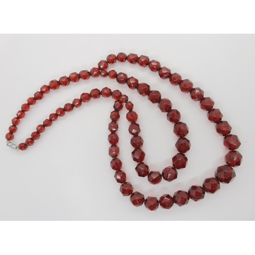 602 - A string of cherry amber coloured beads, weight 49.3gms