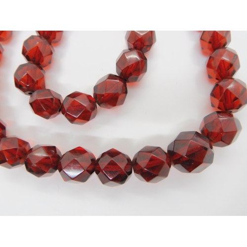 602 - A string of cherry amber coloured beads, weight 49.3gms