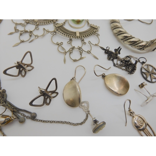 603 - A collection of silver and costume jewellery to include two tribal bangles, Macintosh style items et... 