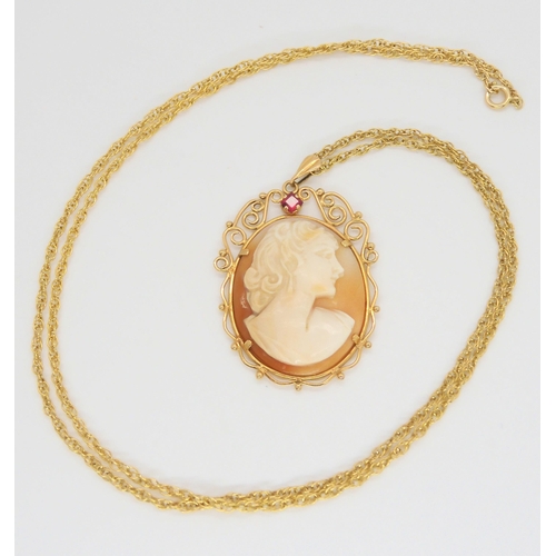 636 - A yellow metal mounted cameo pendant set with a red gem, 4.6cm x 3cm, with a yellow metal rope chain... 