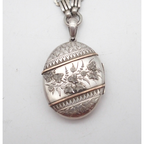 288 - A Victorian silver photo locket pendant, the oval body with engraved floral decoration, the middle w... 