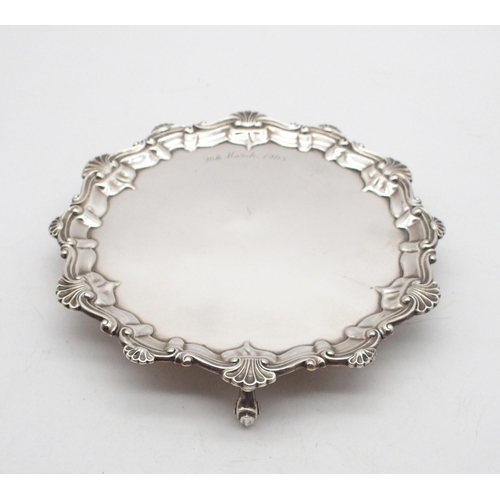 An Edwardian silver card tray, the body engraved '26th March 1965, with scroll and shellwork rim, on three scroll feet, by Barker Brothers Ltd, Birmingham 1903, 18cm, 190gms
