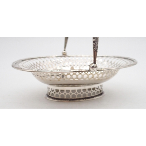 323 - An Edwardian silver swing handled basket, of oval form, the rim and handle with cast leaf decoration... 