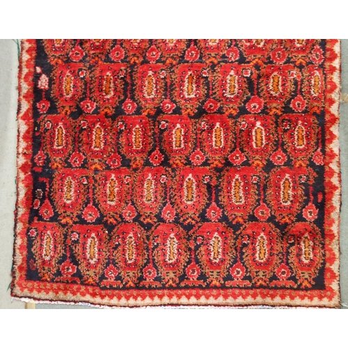 61 - A dark ground hand woven eastern rug with all over lozenge design, 186cm long x 111cm wide