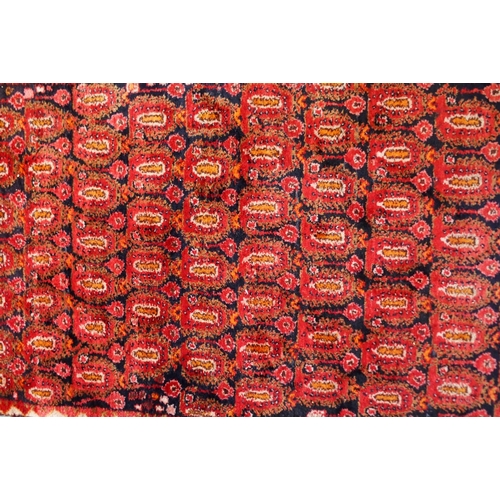 61 - A dark ground hand woven eastern rug with all over lozenge design, 186cm long x 111cm wide