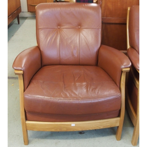 64 - A contemporary Ercol elm and beech framed and chocolate brown leather upholstered three piece suite ... 