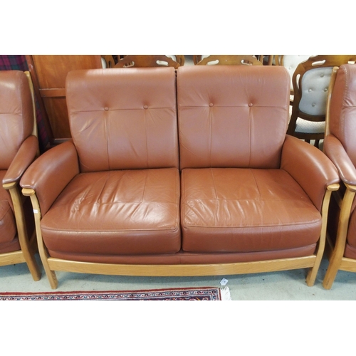 64 - A contemporary Ercol elm and beech framed and chocolate brown leather upholstered three piece suite ... 