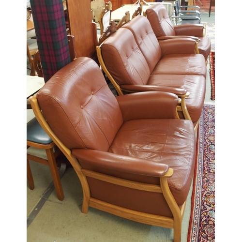 64 - A contemporary Ercol elm and beech framed and chocolate brown leather upholstered three piece suite ... 