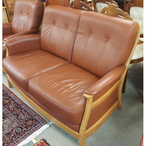 64 - A contemporary Ercol elm and beech framed and chocolate brown leather upholstered three piece suite ... 