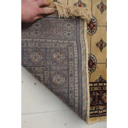 81 - A cream ground Kashmiri rug with all over lozenge design and multicoloured borders, 168cm long x 116... 