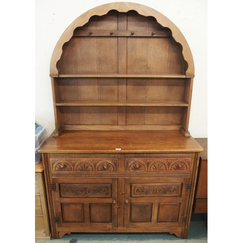 91 - A 20th century oak kitchen dresser with dome topped plate rack over two drawers over two cabinet doo... 