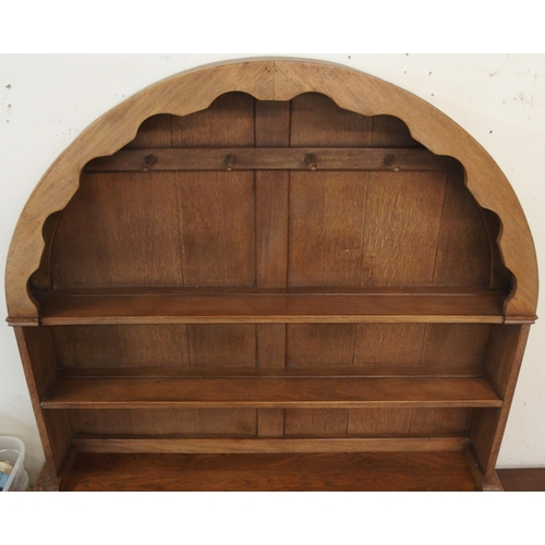 91 - A 20th century oak kitchen dresser with dome topped plate rack over two drawers over two cabinet doo... 