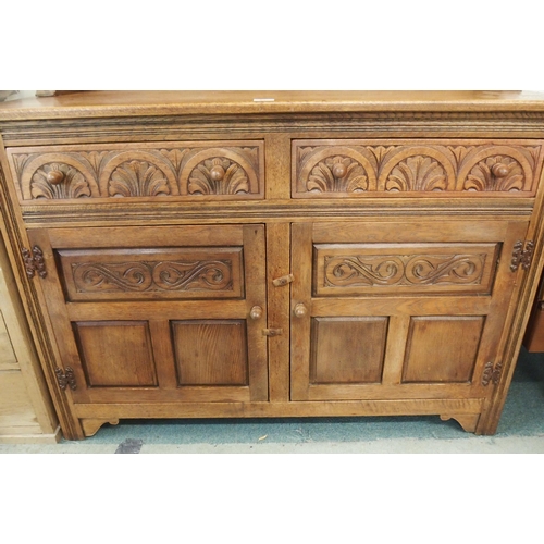 91 - A 20th century oak kitchen dresser with dome topped plate rack over two drawers over two cabinet doo... 