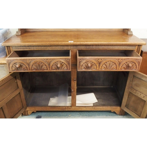 91 - A 20th century oak kitchen dresser with dome topped plate rack over two drawers over two cabinet doo... 