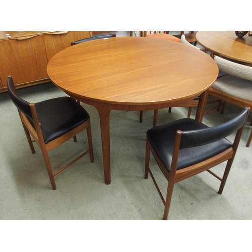 95 - A mid 20th century teak A.H. McIntosh circular extending dining table, 74cm high x 122cm diameter x ... 