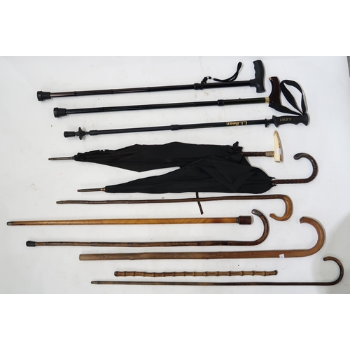 413 - Various walking sticks and umbrellas, two sticks having silver mounts, another with screw-off handle... 