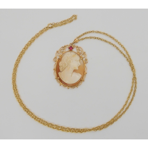 636 - A yellow metal mounted cameo pendant set with a red gem, 4.6cm x 3cm, with a yellow metal rope chain... 