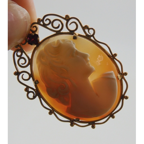 636 - A yellow metal mounted cameo pendant set with a red gem, 4.6cm x 3cm, with a yellow metal rope chain... 