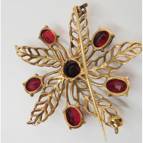 641 - A 9ct gold red gem set flower brooch, diameter 5cm, weight 11gms