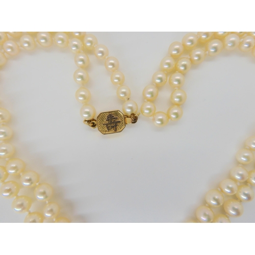 651 - A long string of good quality pearls with a 14k gold, Chinese symbol pattern clasp. Each pearl appro... 