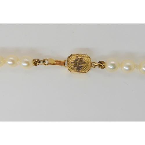 651 - A long string of good quality pearls with a 14k gold, Chinese symbol pattern clasp. Each pearl appro... 