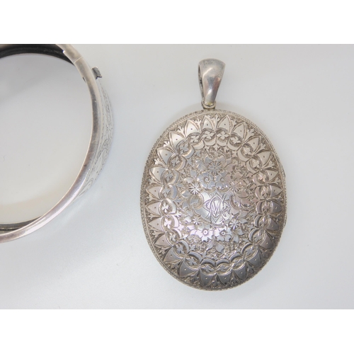 684B - A silver bangle engraved with a bird, and a white metal Victorian heavily engraved locket