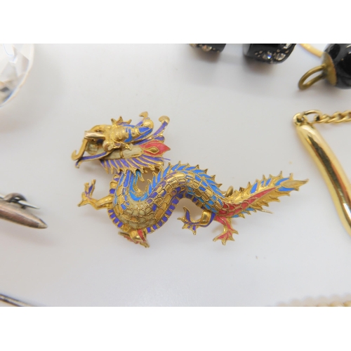 685B - A gilded white metal hummingbird feather embellished dragon brooch, a Nazi cloth badge and a collect... 