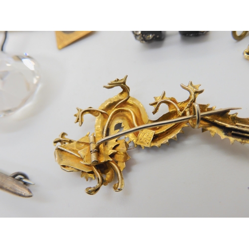 685B - A gilded white metal hummingbird feather embellished dragon brooch, a Nazi cloth badge and a collect... 