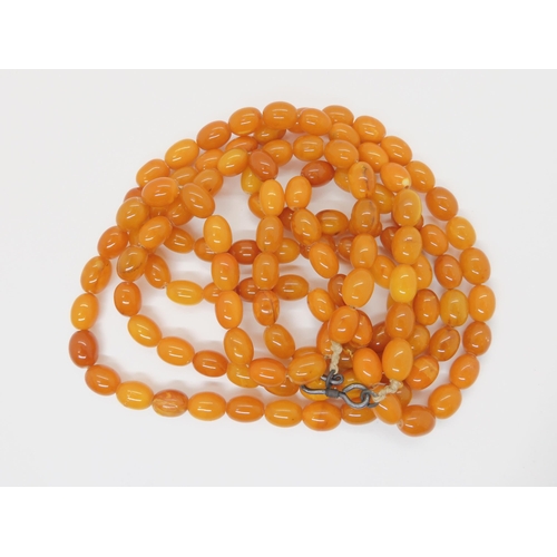 687A - A long string of amber coloured beads, weight 93.8gms