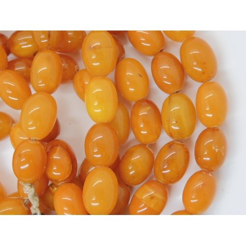 687A - A long string of amber coloured beads, weight 93.8gms