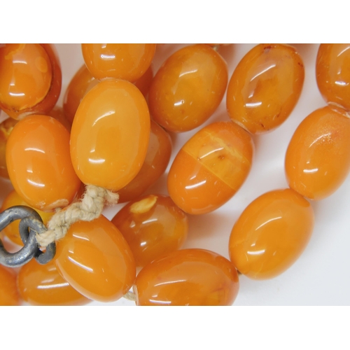 687A - A long string of amber coloured beads, weight 93.8gms