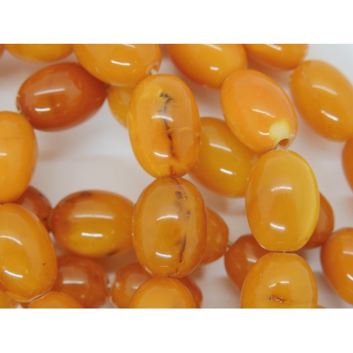 687A - A long string of amber coloured beads, weight 93.8gms