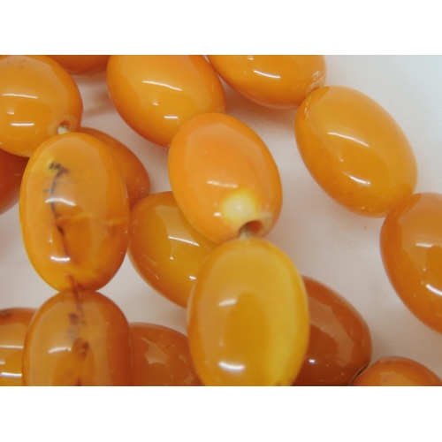 687A - A long string of amber coloured beads, weight 93.8gms