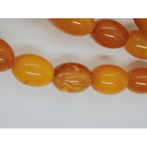 687A - A long string of amber coloured beads, weight 93.8gms