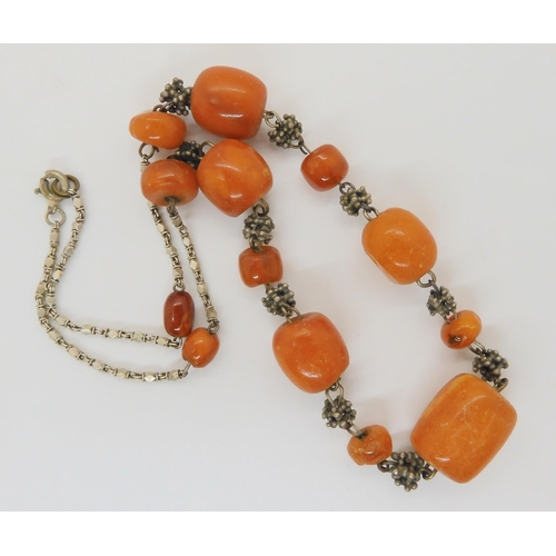 689 - A necklace of amber coloured beads with a white metal decorative chain, weight 21.5gms