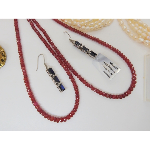 696 - A collection of silver and costume jewellery to include ruby beads, sapphire and white zircon earrin... 