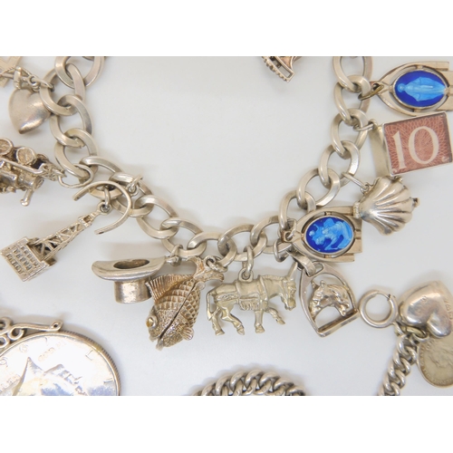 683B - Two silver charm bracelets hung with silver and white metal charms and a 1964 Half Dollar coin on ch... 