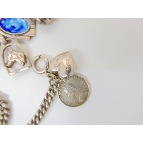 683B - Two silver charm bracelets hung with silver and white metal charms and a 1964 Half Dollar coin on ch... 