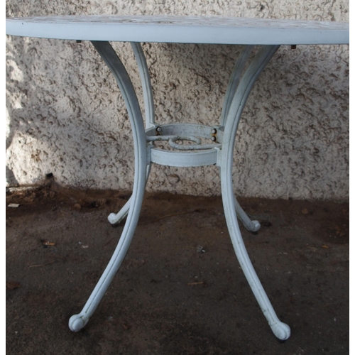 124 - A 20th century white painted cast metal garden table and two chairs (3)