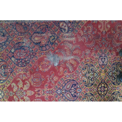 50 - A red ground Tabriz rug with dark blue central medallion, matching spandrels and a yellow floral bor... 