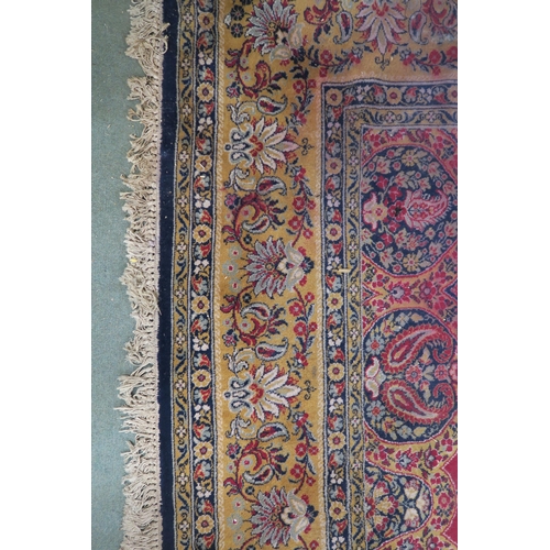50 - A red ground Tabriz rug with dark blue central medallion, matching spandrels and a yellow floral bor... 