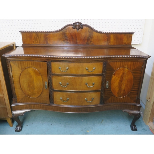 64 - A 20th century mahogany serpentine front sideboard with three central drawers flanked by cabinet doo... 
