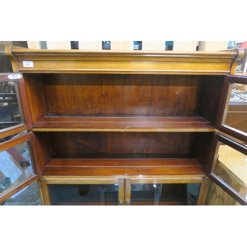 66 - A 20th century mahogany four tier stacking bookcase with glazed doors, 144cm high x 89cm wide x 30cm... 