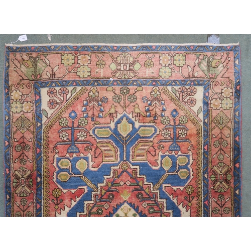 85 - A pink ground Hamadan rug with geometric central medallion, cream floral spandrels and multicoloured... 