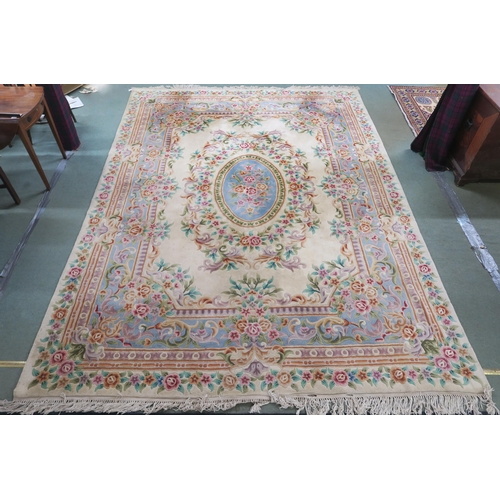 86 - A 20th century cream ground Oriental floral rug with blue oval central medallion, floral spandrel an... 