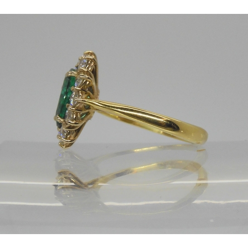 718 - An 18ct gold emerald and diamond cluster ring, set with a 8.6mm x 6.4mm x 3.8mm, oval emerald, furth... 